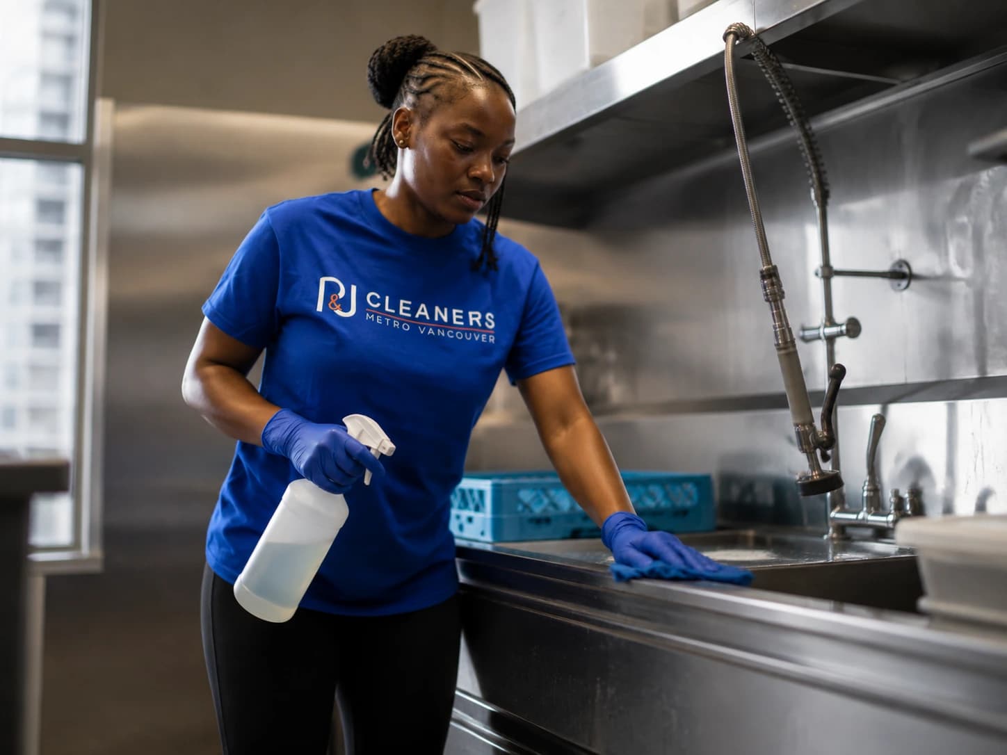 Professional cleaner sanitizing commercial dish washing station