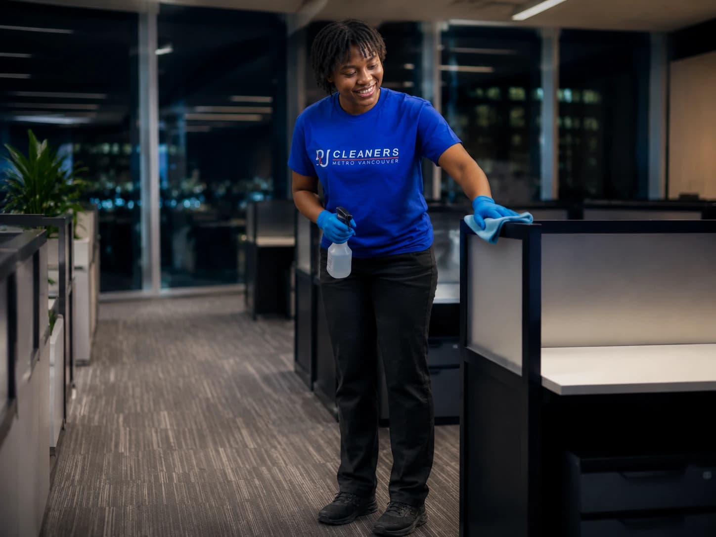 Professional cleaner safely cleaning around electrical equipment in office cubicles
