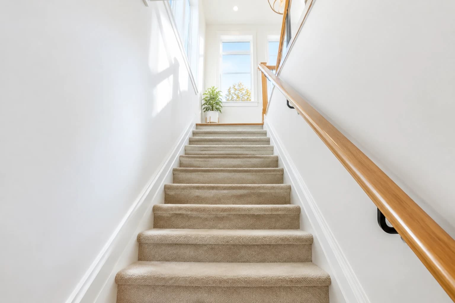 Bright multi-level townhouse staircase in Metro Vancouver with freshly vacuumed treads and spotless white baseboards